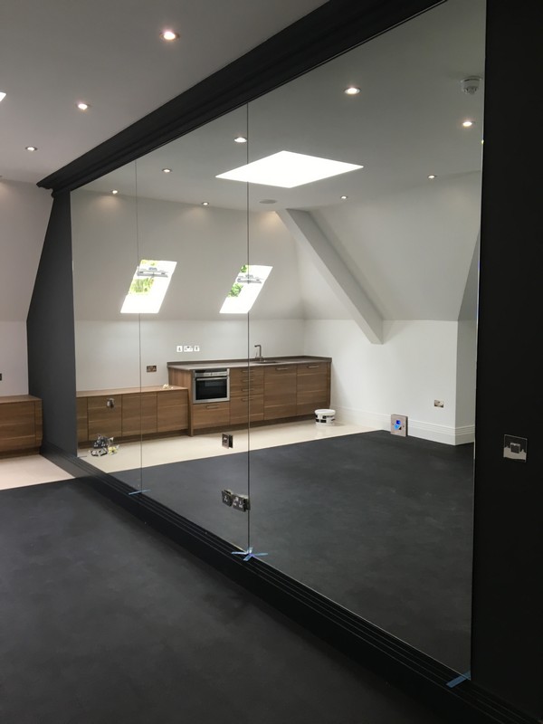 Frameless glass partition in loft conversion by Norbury glaziers